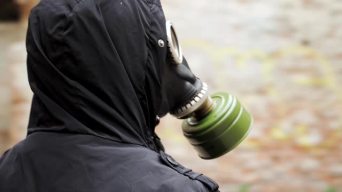 穿着黑色衣服和防毒面具的肖像流浪男子穿过一栋废弃的建筑物。后世界末日世界。跟踪者概念，核或化学战争后_3840X2160_高清视频素材下载