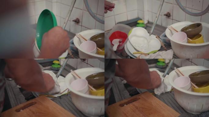 亚洲资深男子在厨房洗碗。