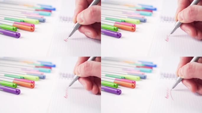 用灰色笔用红色墨水在白色桌子上的笔记本上手写彩色学习用品