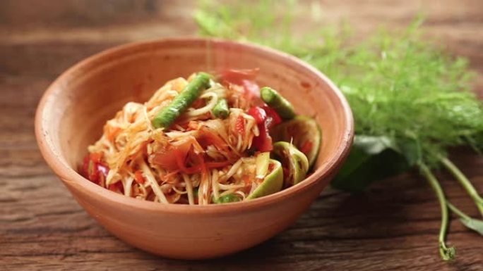 Som Tam是受欢迎的泰国菜。木瓜沙拉配干虾、咸蟹、辣椒、番茄和辛辣香草。配蔬菜。静静在工作室拍摄