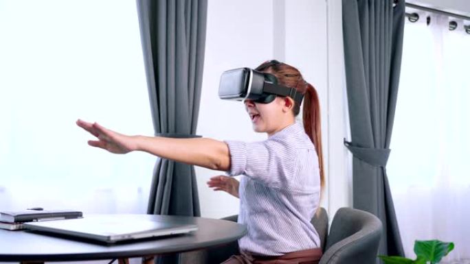 美丽的女人触摸空气玩游戏期间设备虚拟现实 (VR) 耳机眼镜体验，未来技术和娱乐概念。