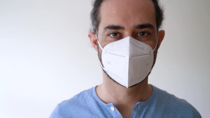 一名年轻男子戴着一次性口罩，以掩盖口腔内可能的细菌。