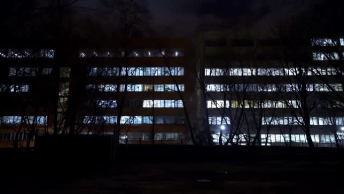 晚上的办公楼。一座办公楼的外部，傍晚时分有带灯的窗户。