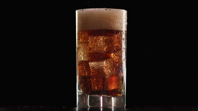 冷提神饮料流充满冰镇慢动作的玻璃杯。用4K红色相机拍摄