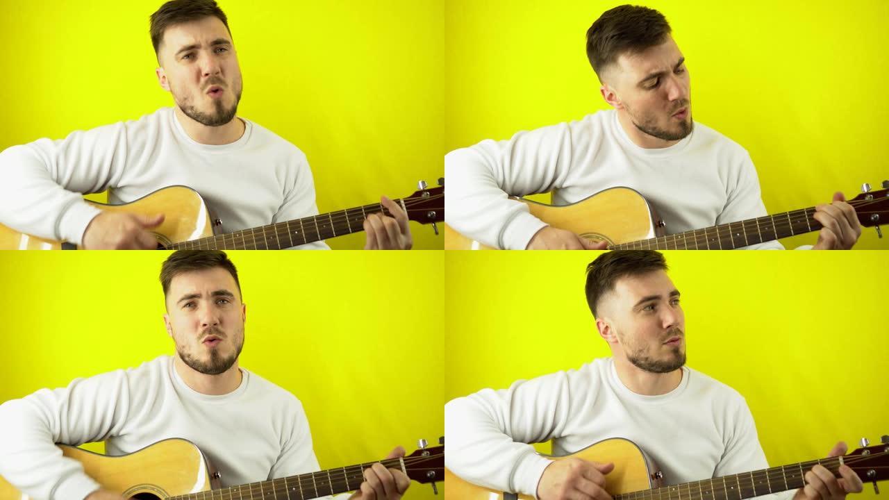 一个年轻人弹吉他，唱一首歌。穿着白色运动衫的白人英俊男子用吉他唱歌。黄色普通背景