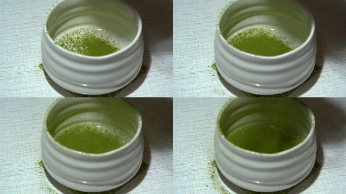 将绿色抹茶粉放入白色碗中。