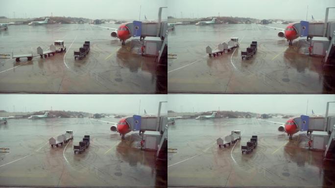 在下雨天准备飞行的飞机上透过机场的窗户观看