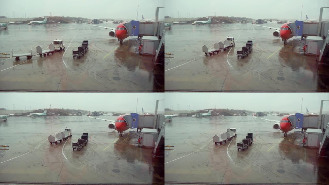 在下雨天准备飞行的飞机上透过机场的窗户观看