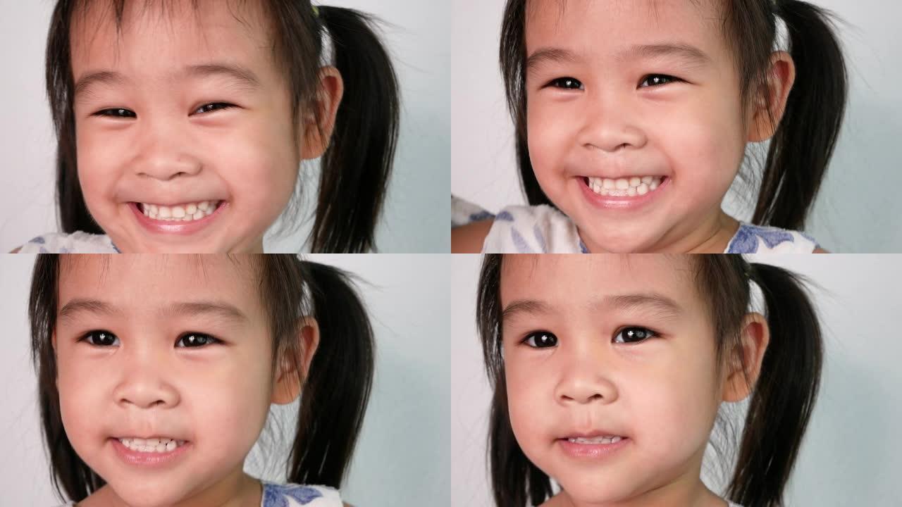 快乐的亚洲小女孩的特写脸享受着跳舞，在白色背景上唱着歌曲《小鲨鱼》。幸福家庭和童年的概念。
