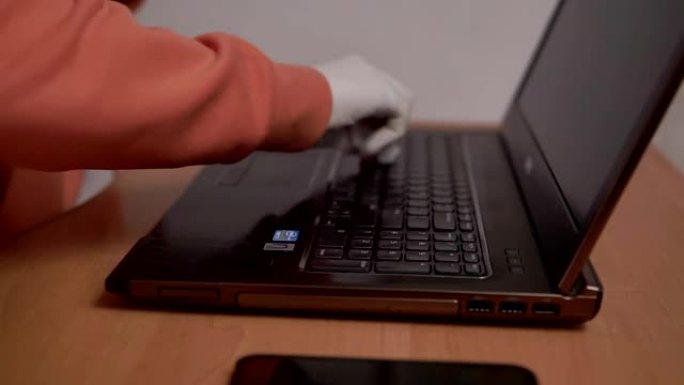 冠状病毒新型冠状病毒肺炎特写女性手使用抗菌湿巾消毒笔记本电脑，在家电脑