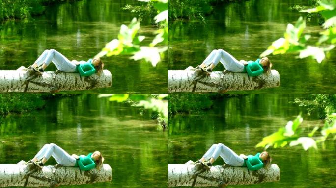 年轻女子在森林灌木丛中的河上默默休息