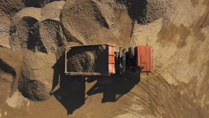 露天采石场自卸车卸砂的俯视图。