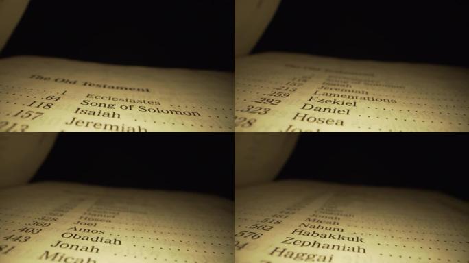 极端微距特写移动滑块拍摄的圣经旧约索引书在国王詹姆斯翻译与红色字母的上帝的话在一个黑暗的背景与独特的
