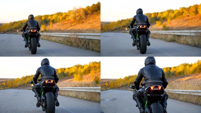 无法识别的人在秋季高速公路上骑着现代运动摩托车。摩托车手在乡间小路上骑摩托车。骑自行车的人在旅行中驾