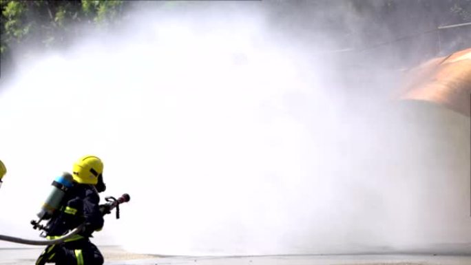 坚强勇敢的消防员使用消防水带灭火