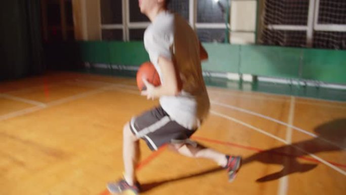 年轻的职业篮球运动员打球将球扔进篮筐夜晚黑暗剪影后视运球特写拼花耐力