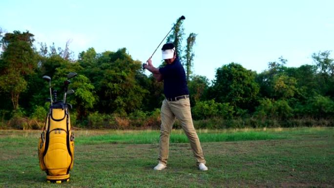 高尔夫球手正在用高尔夫球杆训练