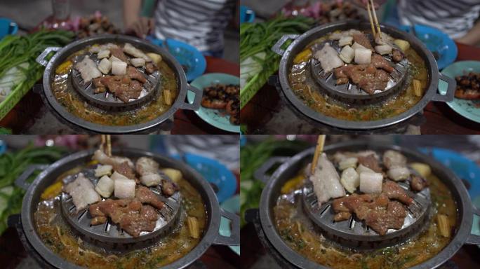 烤盘上的热肉烧烤。泰国风味的韩国烧烤，在热锅上配有猪肉烤架和蔬菜。