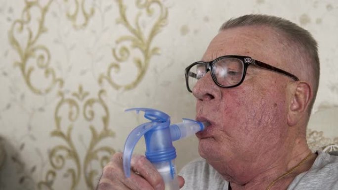 戴眼镜的老人正在使用吸入器并深呼吸