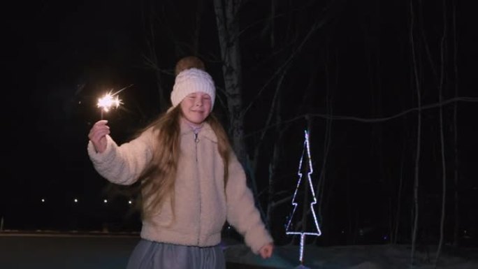 可爱的快乐女孩在晚上拿着烟火和滑冰