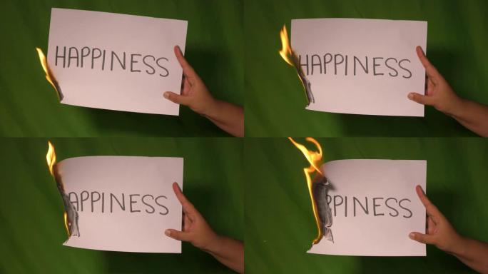 一只手握着燃烧的纸，上面写着幸福的文字。