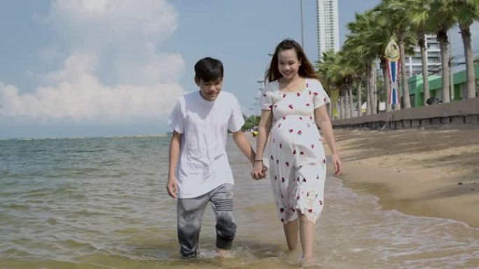 泰国海滩上的年轻丈夫和年轻怀孕的妻子。