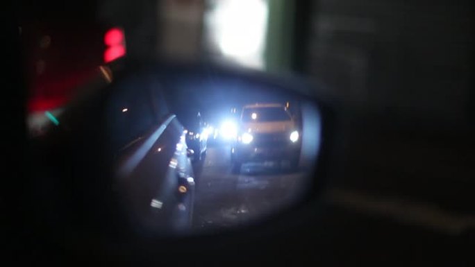 在城市的夜晚，乘客从侧面看后视镜