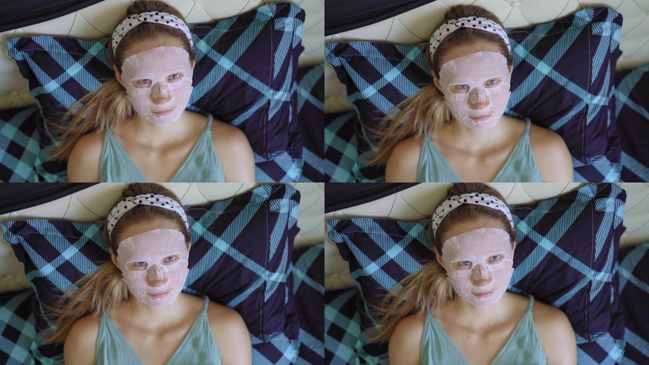 一名年轻女子躺在床上，脸上戴着化妆面具。护肤概念