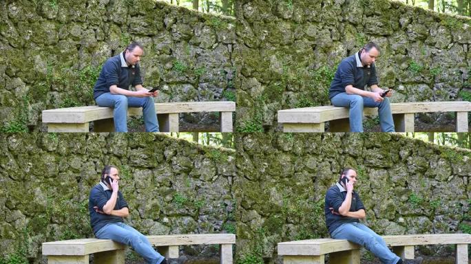 一名男子坐在石凳上，玩手机，接听电话，而背景中有一面旧墙，就像单个的大石头一样