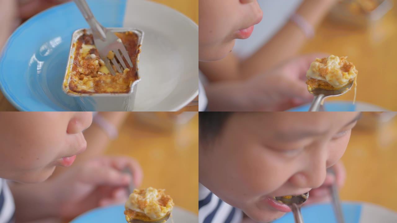 亚洲男孩吃千层面，在家送饭，慢动作。