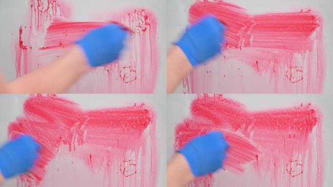 停止冠状病毒概念。用蓝色橡胶手套洗红色油漆的玻璃