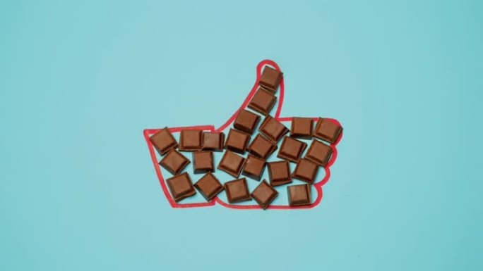 方形的巧克力在蓝色背景上填满了 “喜欢” 的手势。