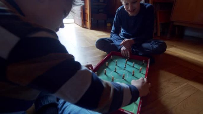 两个小男孩玩和旧足球游戏玩具