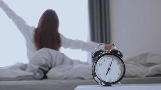 亚洲妇女在床上醒来伸展运动，早上感到快乐和新鲜享受