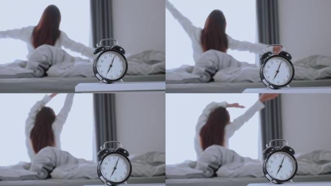 亚洲妇女在床上醒来伸展运动，早上感到快乐和新鲜享受