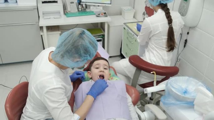 牙医预约的男孩，健康检查，刷牙准备，口腔治疗，消毒，张开嘴，牙医，室内，医生办公室，牙科椅，预防，医