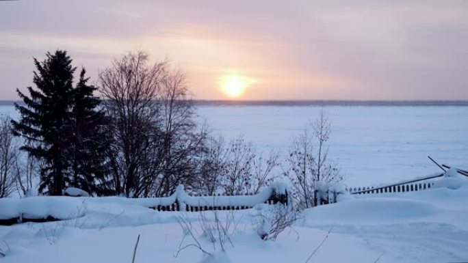 西伯利亚冰冻的叶尼塞河上风景如画的日落。红色的太阳在冬天的森林里落山。4K