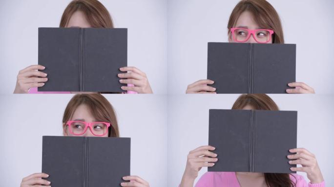 年轻的亚洲书呆子女人的脸与书的思维
