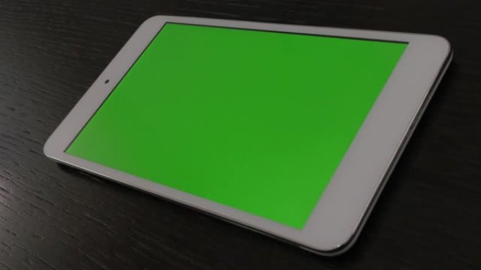 室内沙发上裸露的银平板电脑，绿屏显示4K