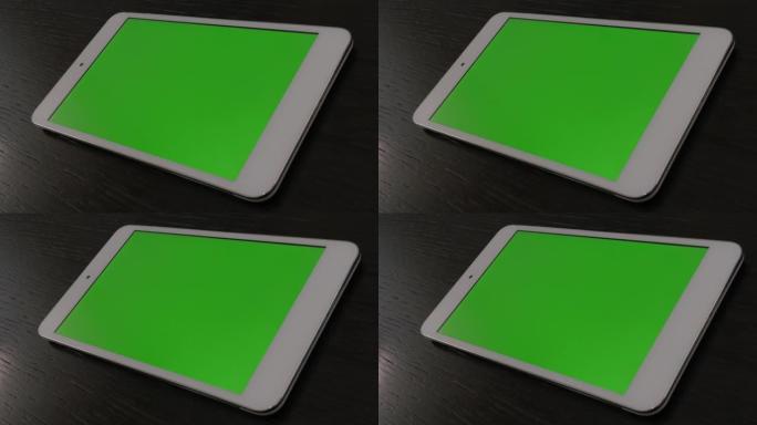 室内沙发上裸露的银平板电脑，绿屏显示4K