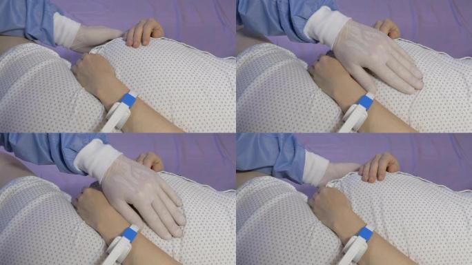 外科医生妇科医生戴着橡胶手套检查一名孕妇。