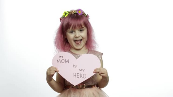 女童公主抱着粉红色的纸心，上面有关于母亲的文字。母亲节