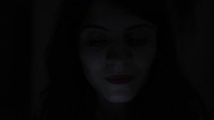 女人脸看着蓝光屏幕的人晚上在黑暗中使用手机