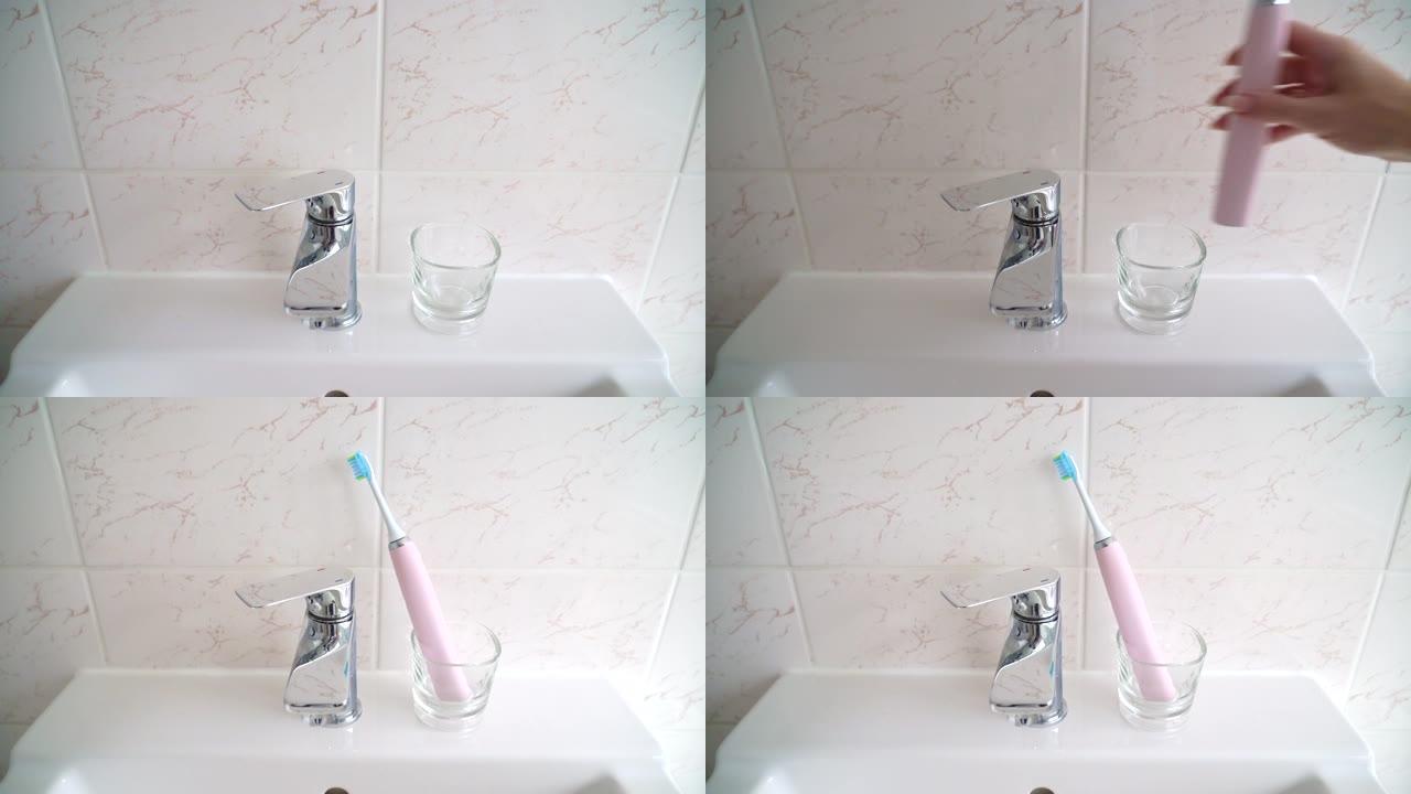 家里浴室里的粉色电动牙刷和玻璃。与口腔护理产品和牙科护理工具组成。