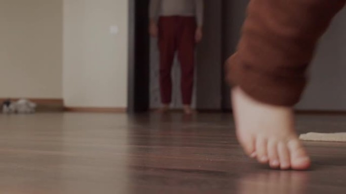 孩子的脚在家里的地板上。婴儿腿。近距离拍摄。