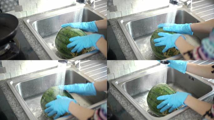 妇女的手在手套洗西瓜