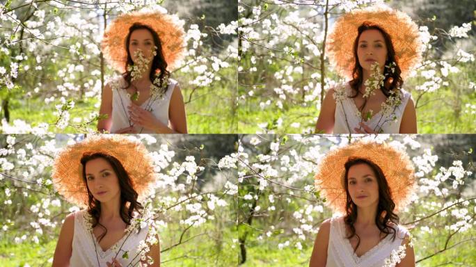 戴着草帽长发的黑发女人站在苹果园