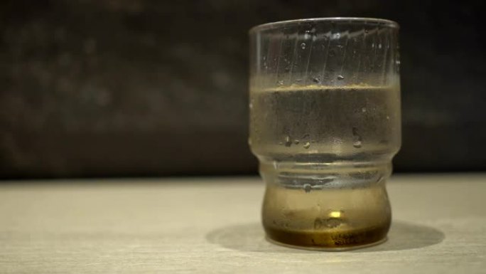 木制桌子上有水的玻璃杯。