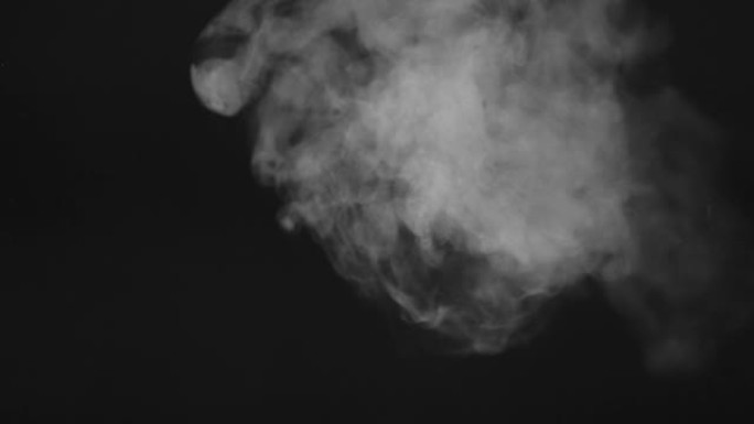 在黑色背景上移动白烟或蒸气的视频。