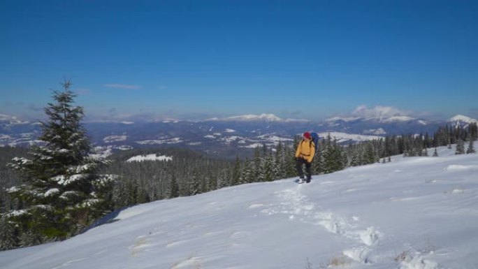 一个背着背包的男人冬天在山里旅行